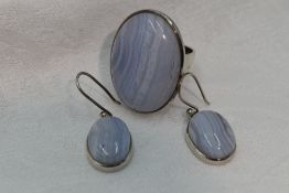 A lady's oversized dress ring having an oval white striped quartz cabouchon in a collared mount to