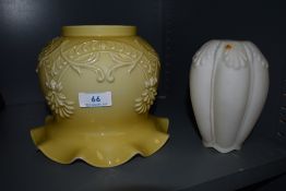 Two vintage glass lamp shades, one having embossed floral detailing and fluted edges.
