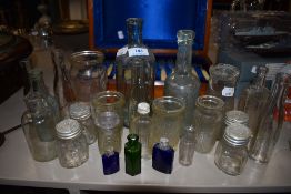 A good quantity of vintage and antique glass bottles and jars, including coloured perfume and poison