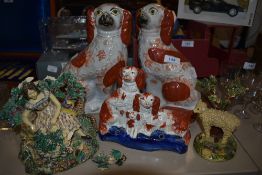 An assortment of Staffordshire dogs and similar figurine depicting a sheep and the other a girl.