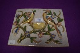 A portuguese tile or wall mounted plaque having raised birds aside a nest intertwined with flowers.
