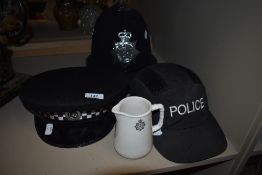 One police helmet for Cumbria police,a hat and a cap. Also a vintage Lancashire Constabulary milk