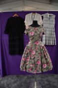 Three vintage 1950s dresses and a blouse, two cotton dresses, one having pink flowers on a grey