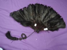A late 19th/early 20th century black ostrich feather fan,a little wear in places and could do with