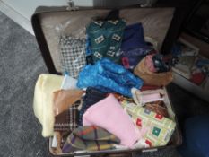 A suitcase containing an array of vintage fabrics, predominantly 50s and 60s, some still in original