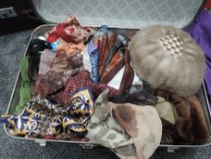 A suitcase full of vintage and retro gloves, scarves and a mink hat.