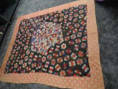 A stunning Victorian patchwork quilt having hexagons to centre surrounded by a border. beautifully
