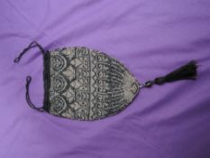 An early 20th century drawstring evening bag having extensive beadwork in black,silver and gold with