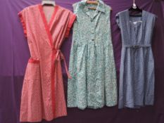 A fitted 1950s blue and white dress with sweetheart neckline and belt, an early 60s floral cotton