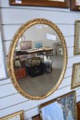 An oval bevelled glass mirror having gilt effect frame.
