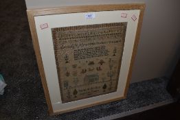 An intricate needle work sampler dated 1835 depicting alphabet with animal, plant characters and