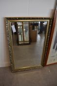 A bevel edged mirror with plaster style frame