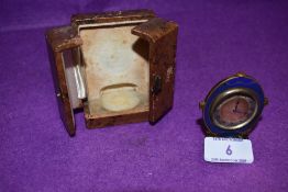 An antique miniature cased travel clock having enamel decoration with brass case working condition