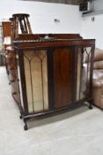 An early to mid 20th Century mahogany display cabinet, on ball and claw feet, central enclosed