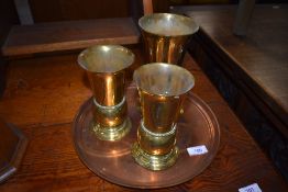 A set of three solid brass cast communion or similar service chalice
