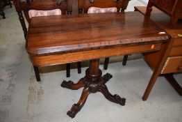 A William IV Rosewood fold over tea table, hollow section under top, on central turned column over