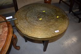 A traditonal Indian brass top coffee table on plain wood frame, diameter approx. 60cm