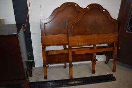 A pair of mid 20th Century mahogany and walnut single bed frames