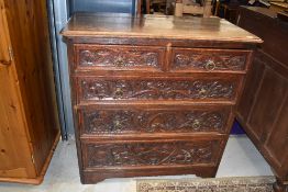 A 19th Century oak chest of two over three drawers, hvaing carved draw fronts and brass ring