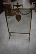 A traditional brass mirrored fire screen having urn and swag decoration, width approx. 45cm
