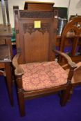 A large Ecclesiastical high backed armed priest or similar chair in oak, having carved flower and