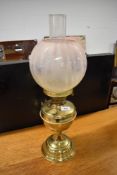 A Victorian style brass oil lamp, with glass chimney and opaque shade