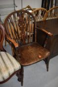 A traditional oak wheelback armchair, width approx 56cm