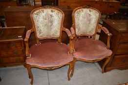A pair of French style armchairs having upholstered seats and backs
