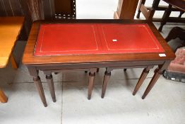 A reproduction leather top coffee table with two occasional tables nested under, approx. 76 x 37cm