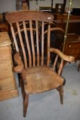 A traditional stripped rail back armchair, joints loose, with repair