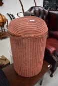 A vintage Lloyd Loom style dome top linen basket, in salmon pink