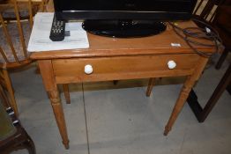 A Victorian stripped pine side table having frieze drawer with ceramic handles, on turned legs,