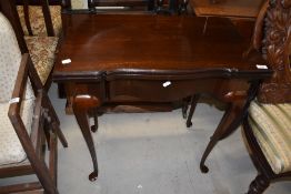 An early 20th Century mahogany fold over card table, having shaped edge on cabriole legsm width
