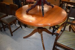 A modern extending dining table, in a light colour, having shaped edge, possibly Rossmore or similar