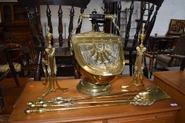 A 19th Century brass coal helmet, fire dogs and irons