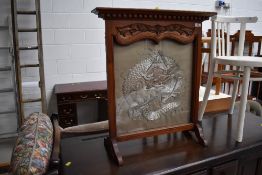 A mahogany framed firescreen having Oriental style silkwork inset