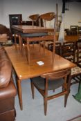 A vintage G plan teak extending dining table and four G plan open back dining chairs, table has