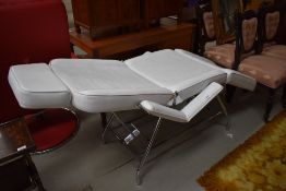 A modern white leather consultation couch, possible medical or beauty treatment use