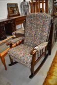 A dark stained Ercol style upholstered rocking chair