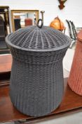 A modern Lloyd loom style linen basket, labelled Dryad, in black