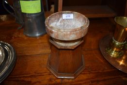 An ecclesiastical ceremonial bowl in a carved stone with hexagonal oak plinth
