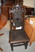 A Jacobean style oak hall chair having detailed dragon and angel leather work to seat and foliate