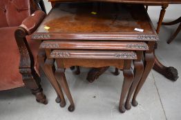 A nest of three mid 20th Century walnut tables