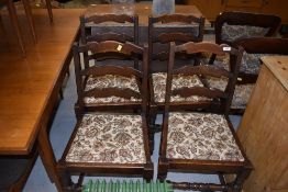 A set of four traditional oak ladder back dining chairs having upholstered seats