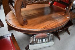 A Victorian mahogany loo style table, oval top over quadruple carved splay legs and scroll feet,