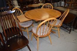 A beautiful Ercol extending table and set of four hoop and stick back chairs, gold badged, length