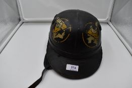 A 1950's black National Benzole Corker Motor Cycle Helmet, having emblem motif