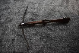 An Antique Crossbow with wooden stock, metal fittings and bow, folding loading mechanism in