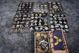 A large collection of mainly Cap Badges including Bombay Pioneers, Tyneside Scottish, The Buffs, The