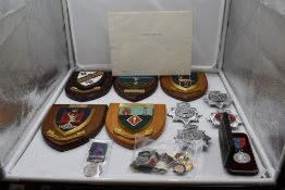 A collection of five Regiment Shields and four Police Cap Badges including South Wales,